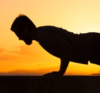 Silhouette of male doing push ups.