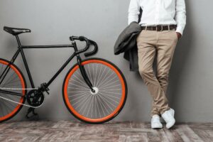 image of lower half of man with posing with his jacket and a road bike