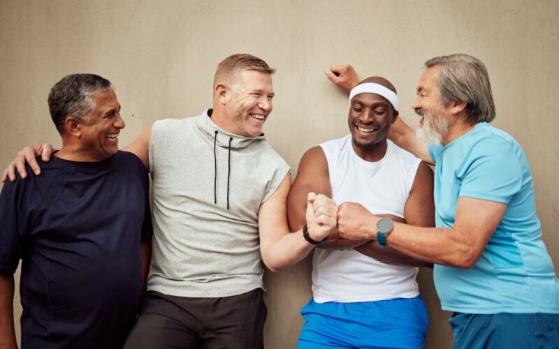 Happy, fitness or friends fist bump with goals bonding after workout, training or running exercise. Motivation, mature runners or healthy group of senior men with support or target ready for running
